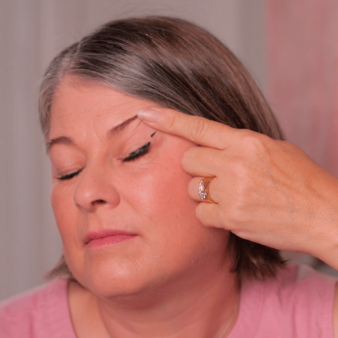 Woman with a hand pointing to her eye, possibly indicating an issue or concern.
